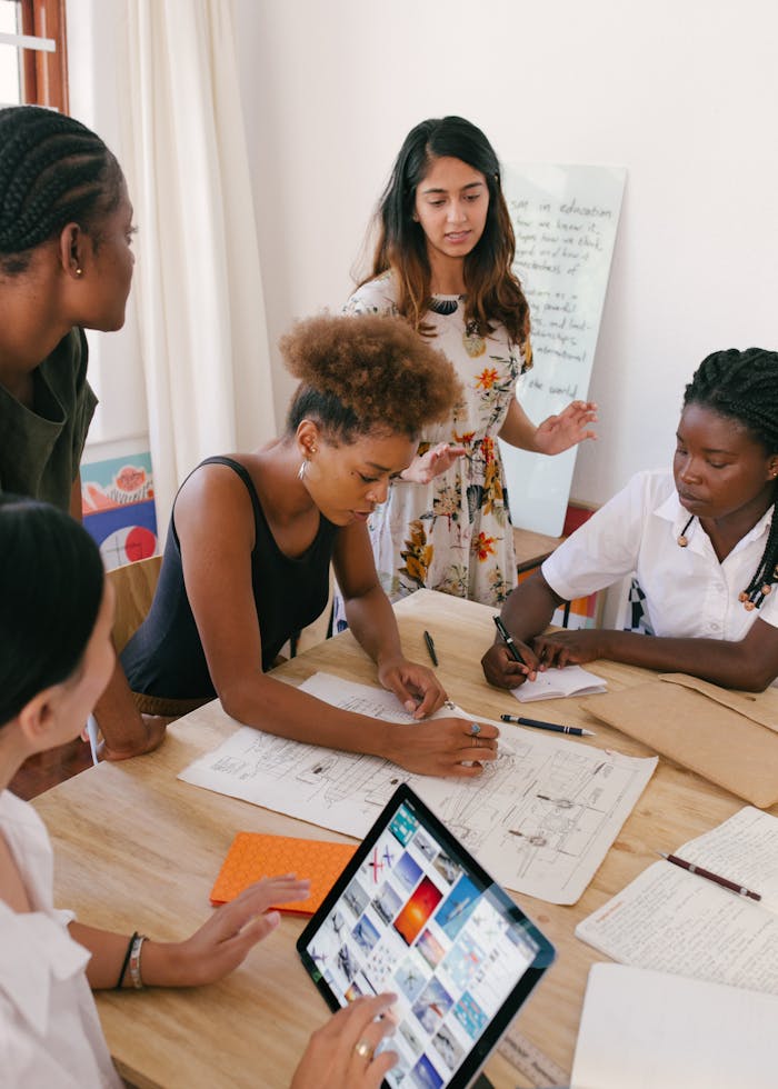 experience-img Group of women collaborating on a creative project in a modern office environment.